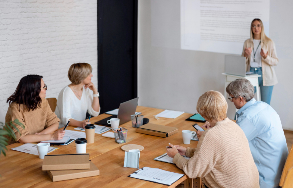 Small-group corporate training session in a bright office, participants seated around a table